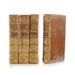 Four vintage leather-bound books with ornate gold detailing on their spines, arranged in a row.