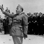 Black and white photograph of General Francisco Franco in military uniform addressing troops.